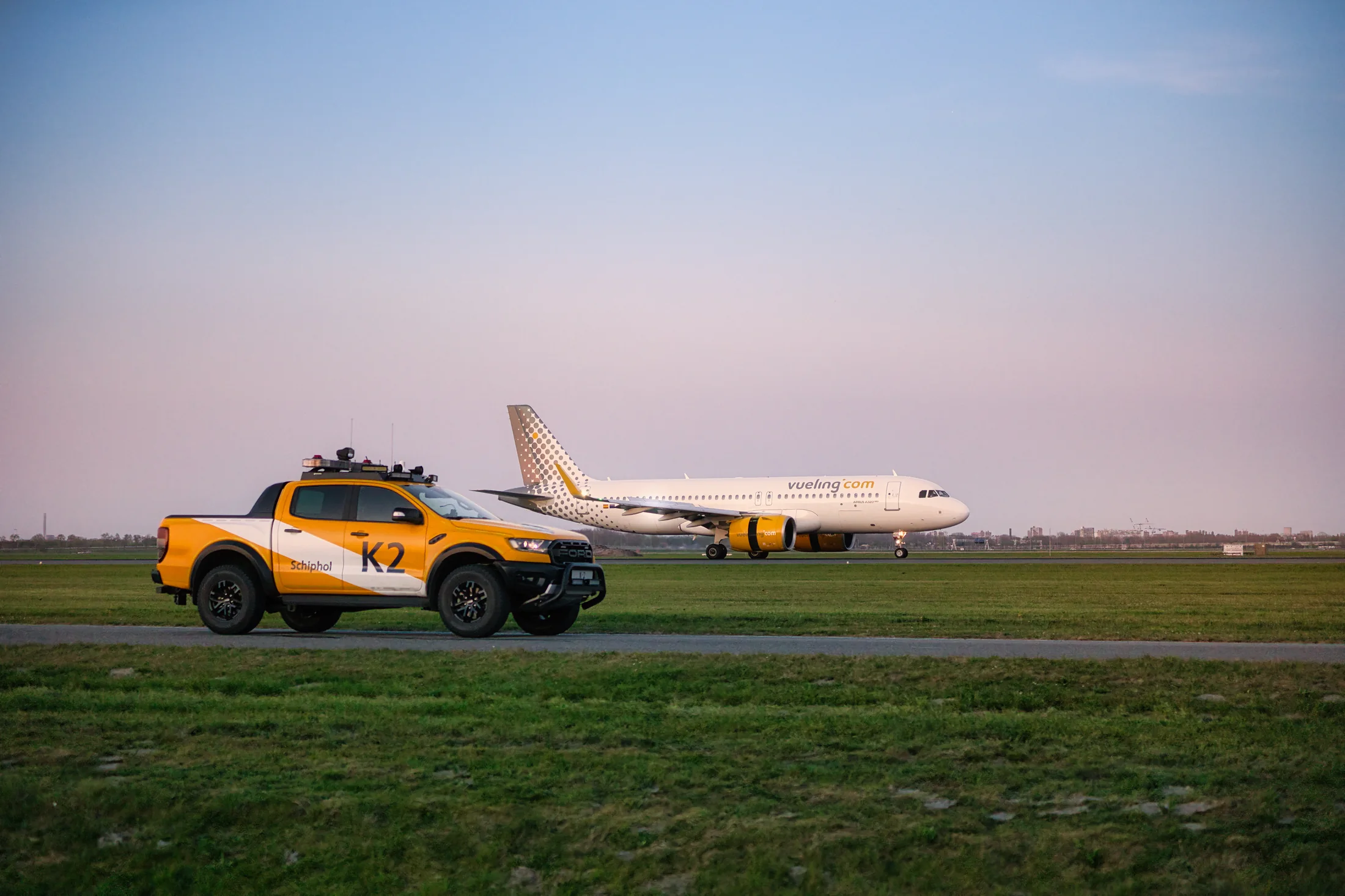 Vueling-Airbus EC-NDB vor einem gelben Flughafenfahrzeug.