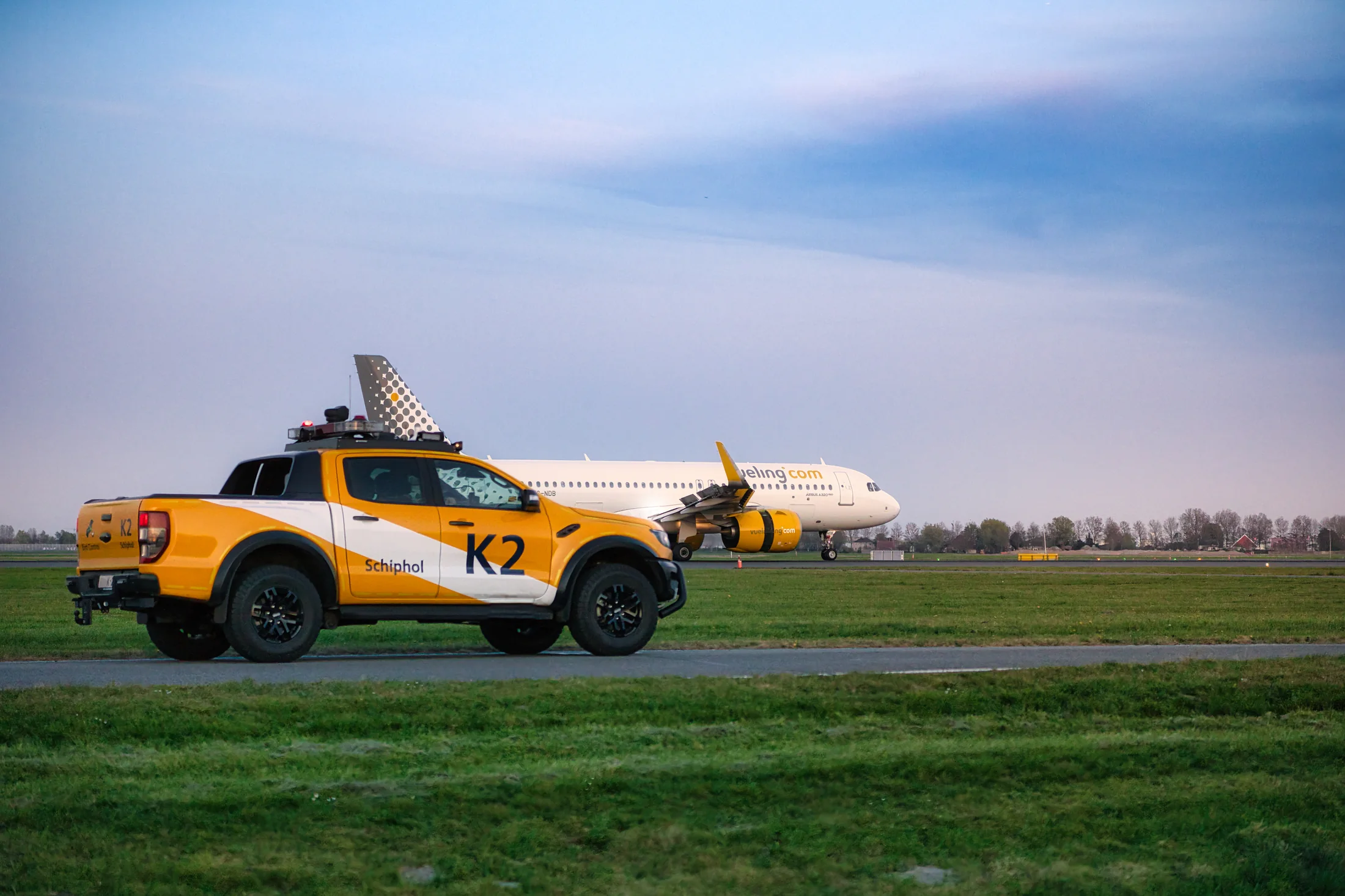 Vueling-Airbus EC-NDB mit einem Flughafenfahrzeug im Vordergrund.