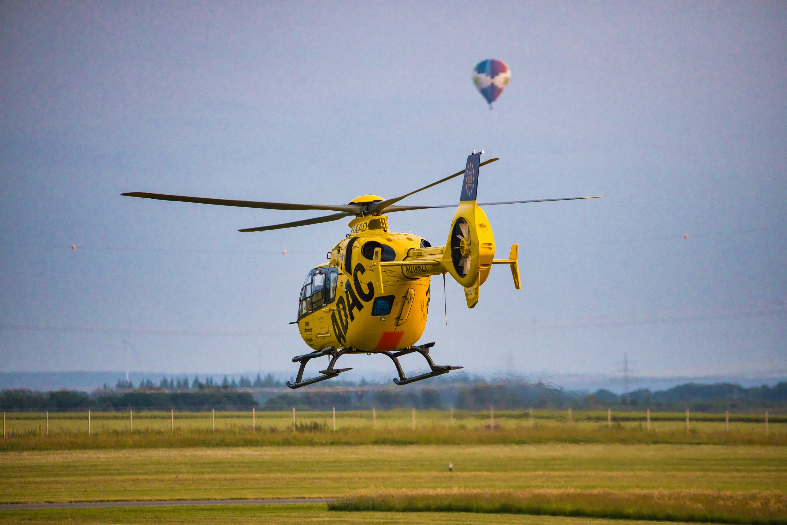 D-HXAD im Flug; ein Heißluftballon steht am Himmel darüber.